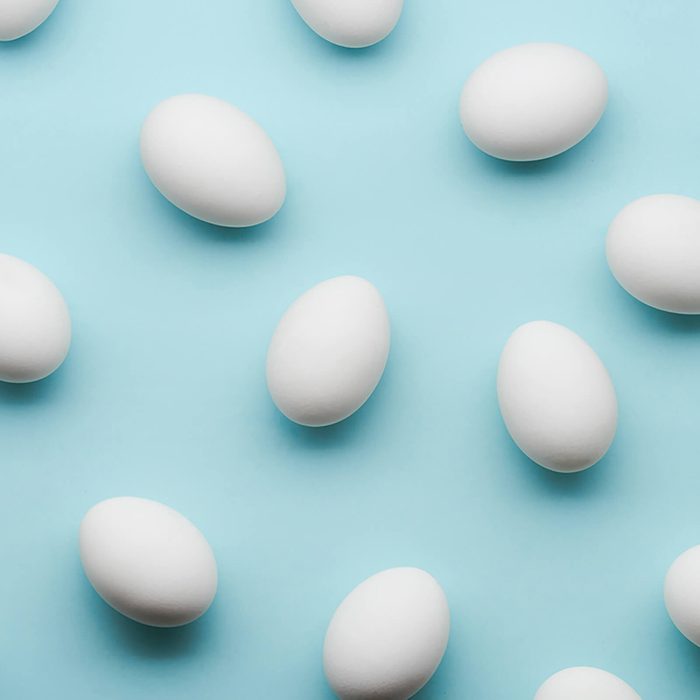 White eggs chaotic pattern on mint color background