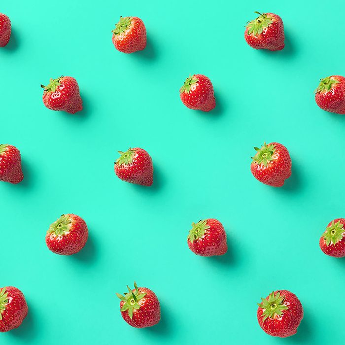 Colorful pattern of strawberries on blue background.