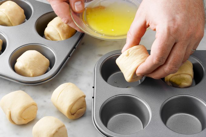 putting dough balls in a muffin tray