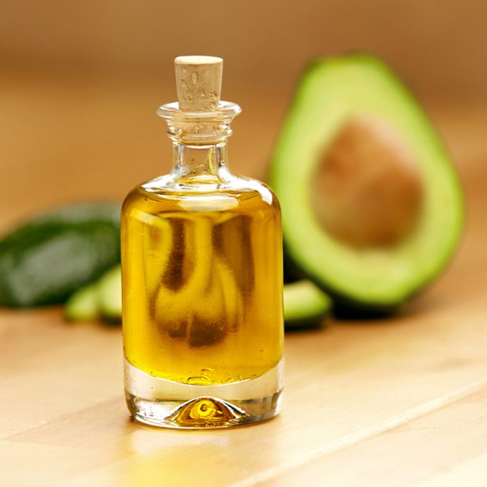 Food Ingredients. Avocado Oil In Bottle With Avocado On Table