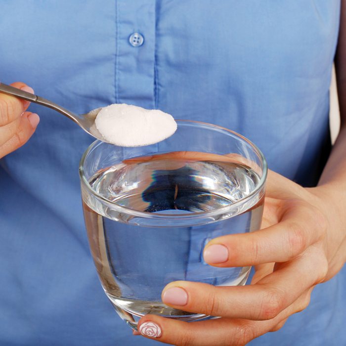 Girl dilutes the baking soda in a glass of water