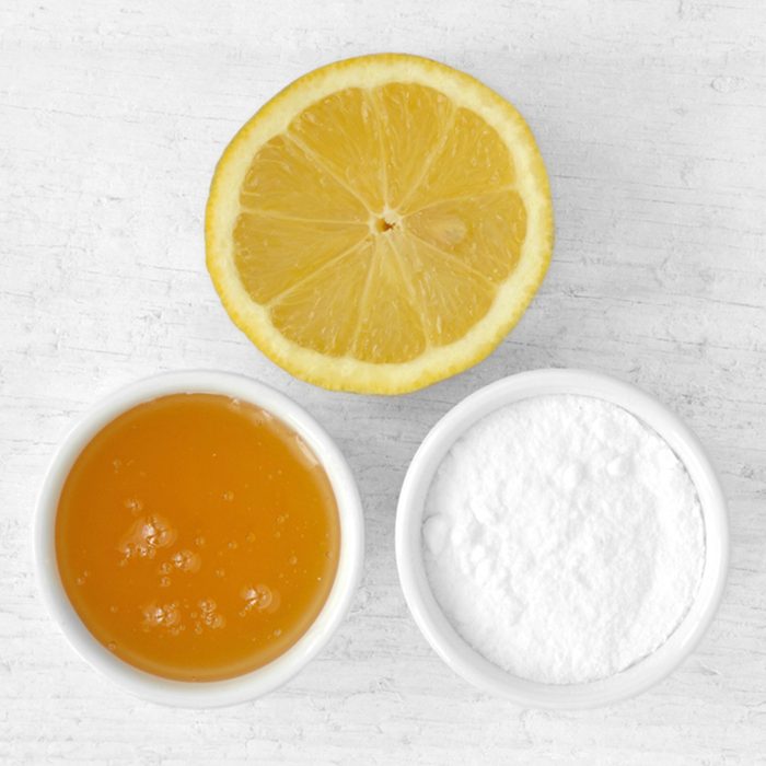 Homemade face mask made out of lemon juice, honey and baking soda on wooden background