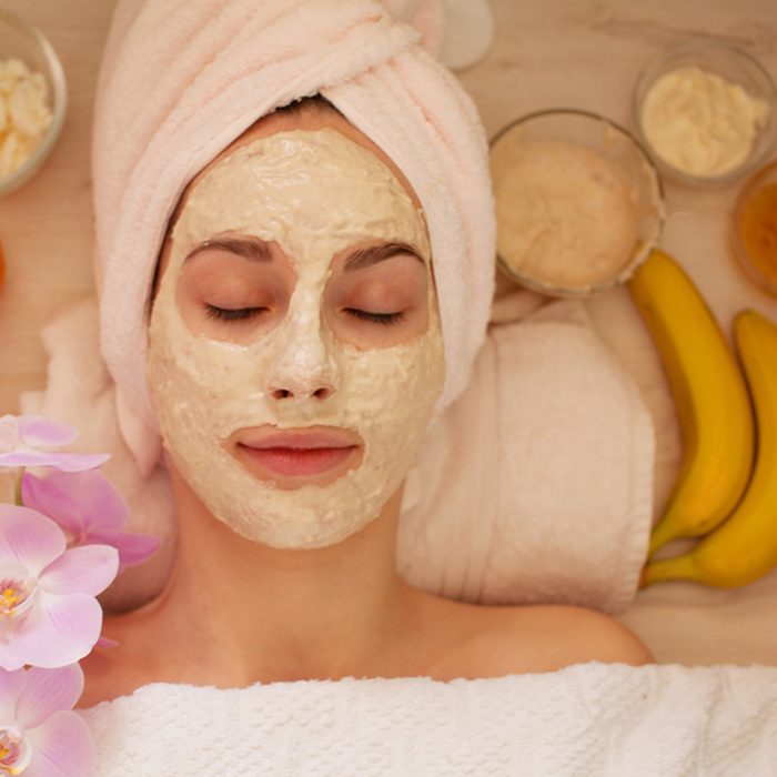 Spa Woman applying Facial clay Mask.