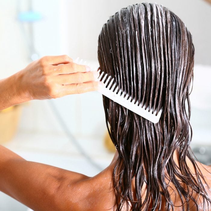 woman applying hair care with a comb
