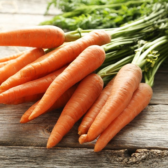 Fresh and sweet carrot on a grey wooden table