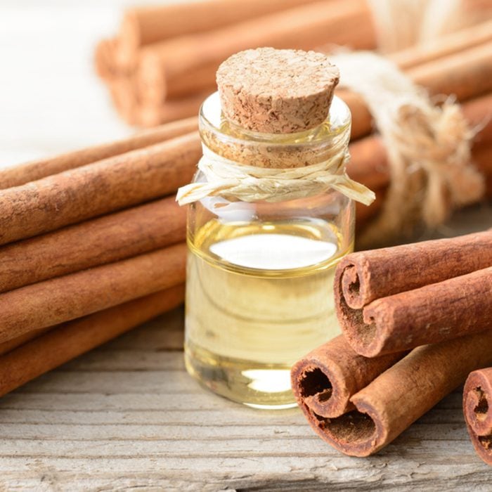 cinnamon oil and cinnamon sticks on the wooden board