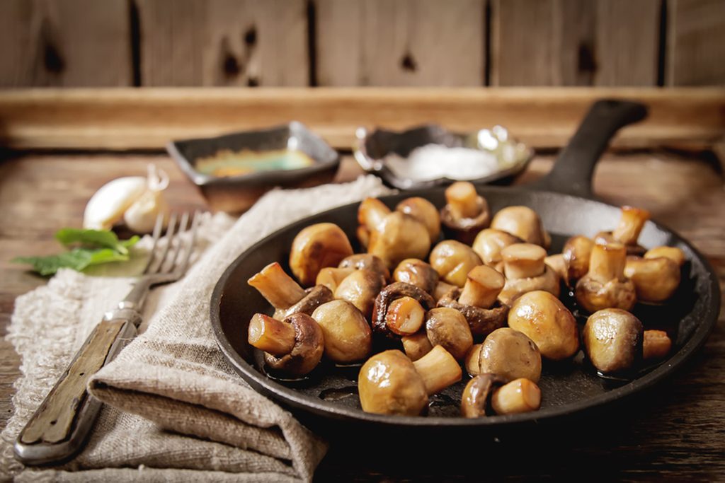 Fried mushrooms with salt and pepper on a wooden background