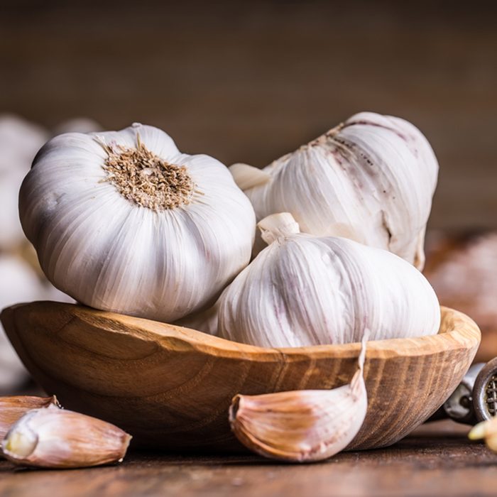 Garlic Cloves and Bulb in vintage wooden bowl.