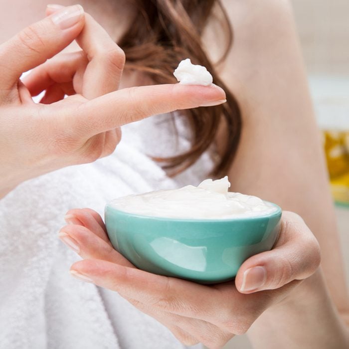 Closeup of woman hands holding a bowl with nourishing mask for applying to hair or skin