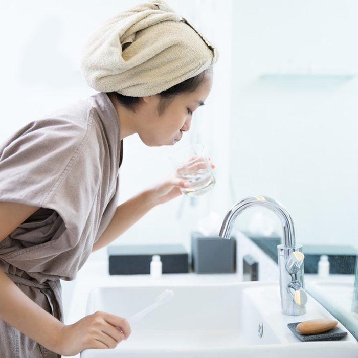 Asian women are mouthwash after brushing teeth in the bathroom.