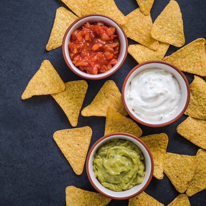 nachos with dips border background on dark slate