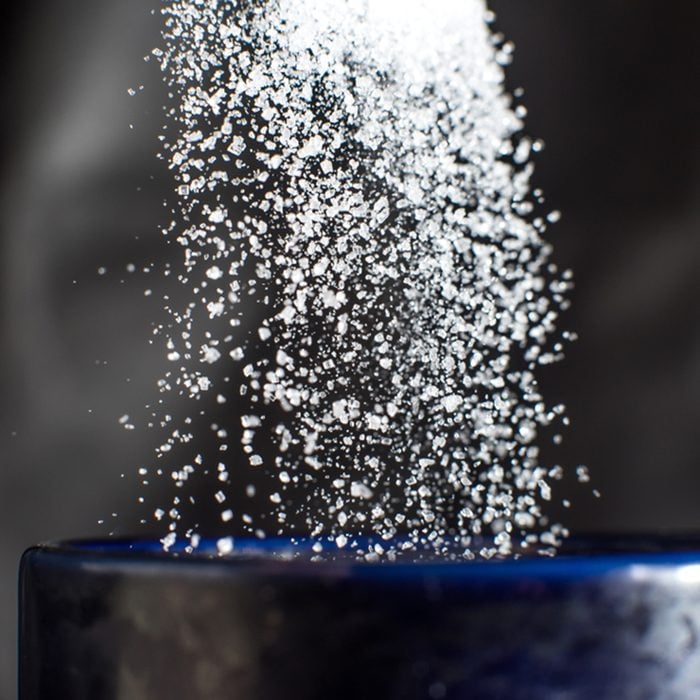 Salt pouring down into blue cup