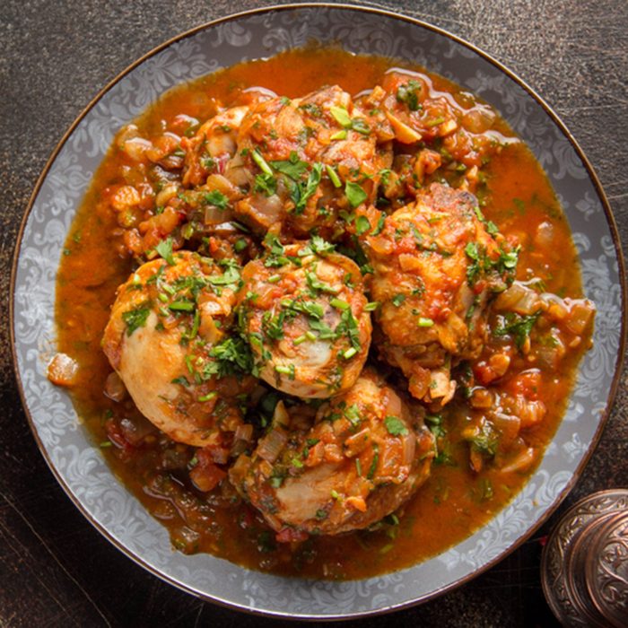Chicken in tomato sauce with herbs and onions, cilantro parsley mint, traditional Oriental dish chakhokhbili, delicious homemade food. On dark background; Shutterstock ID 1251565582; Job (TFH, TOH, RD, BNB, CWM, CM): TOH