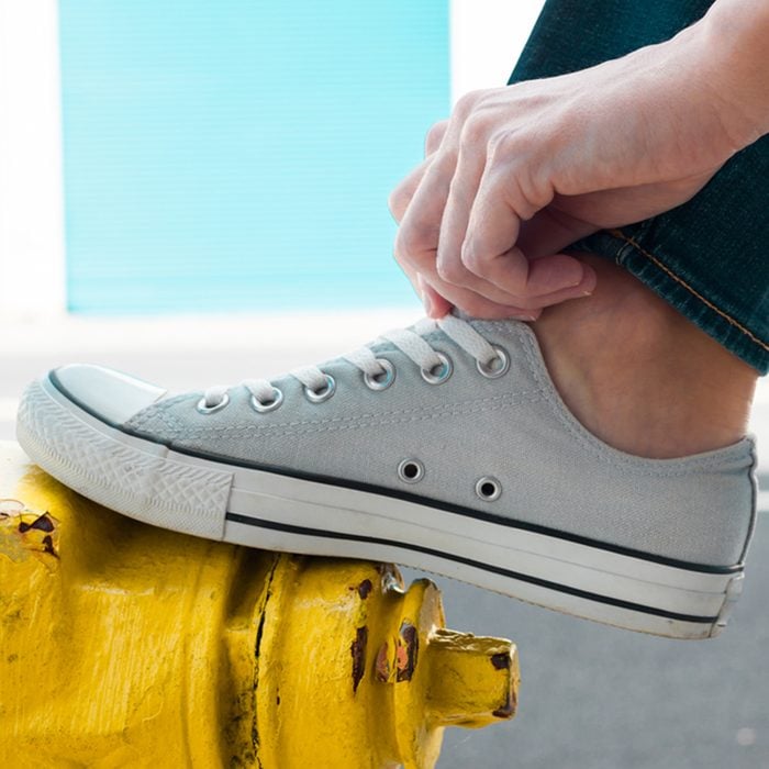 Person putting on pair of shoes.