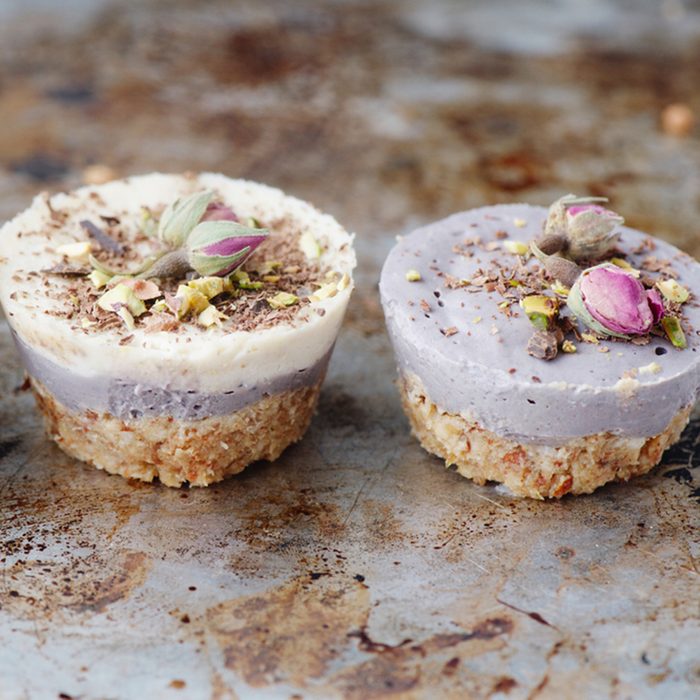 Vegan mini cheesecakes with blueberry and white chocolate layer with adding of cashews, cacao butter and coconut milk, and base made of almonds, shredded coconut and medjool dates 