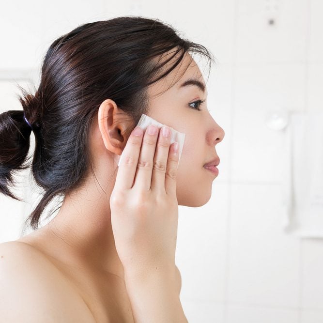 Beautiful woman removing makeup from her face in bathroom.; Shutterstock ID 557276806