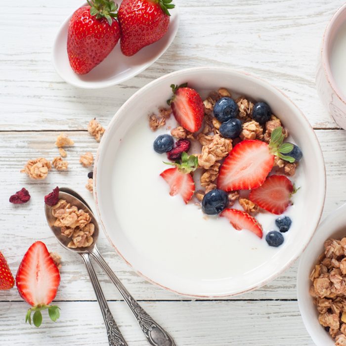 Yogurt with granola, strawberry and blueberry.