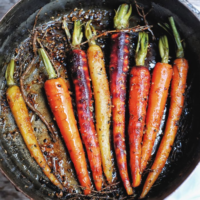 Grilled colorful rainbow carrot in sesame Teriyaki and Mirin sauce, mix herbs, thyme, and Japanese spices in traditional copper pot.