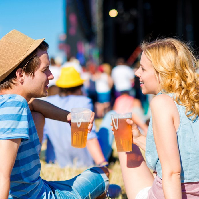 Young couple with beer at summer music festival