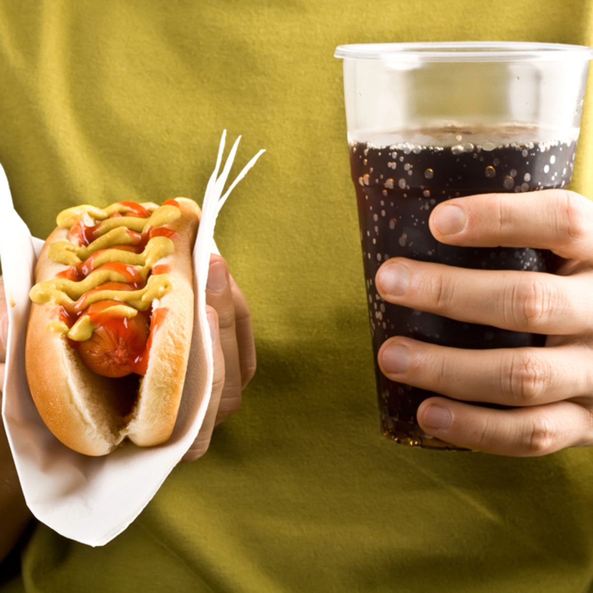 classic hot dog with mustard and ketchup and cola holding in hands; Shutterstock ID 68139490; Job (TFH, TOH, RD, BNB, CWM, CM): TOH