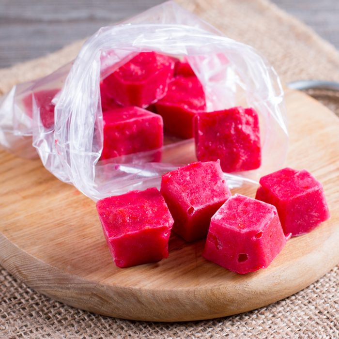 Frozen berry cubes in a bag on a cutting board on a table; Shutterstock ID 770195506