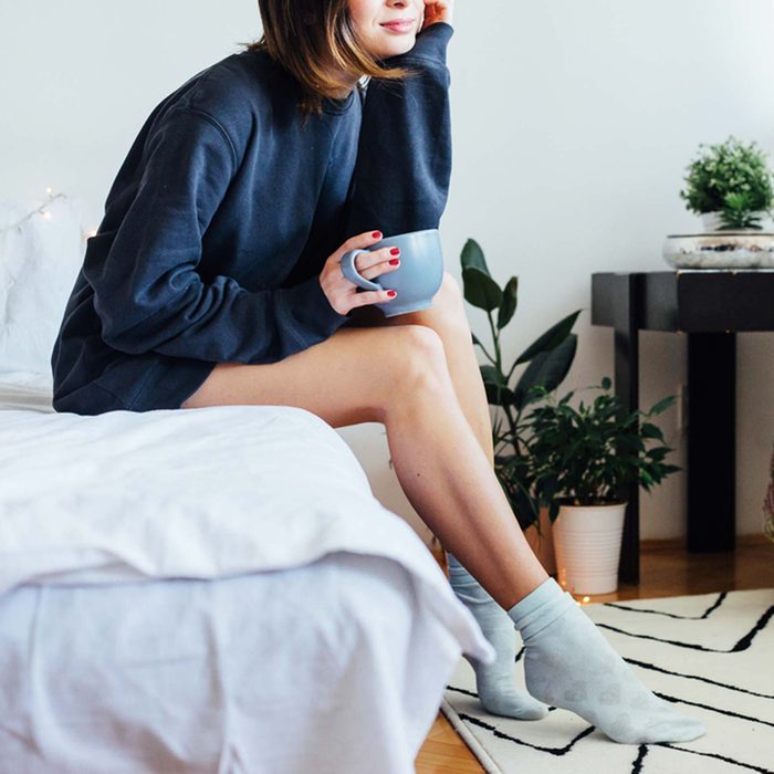 Woman relaxing with mug on bed