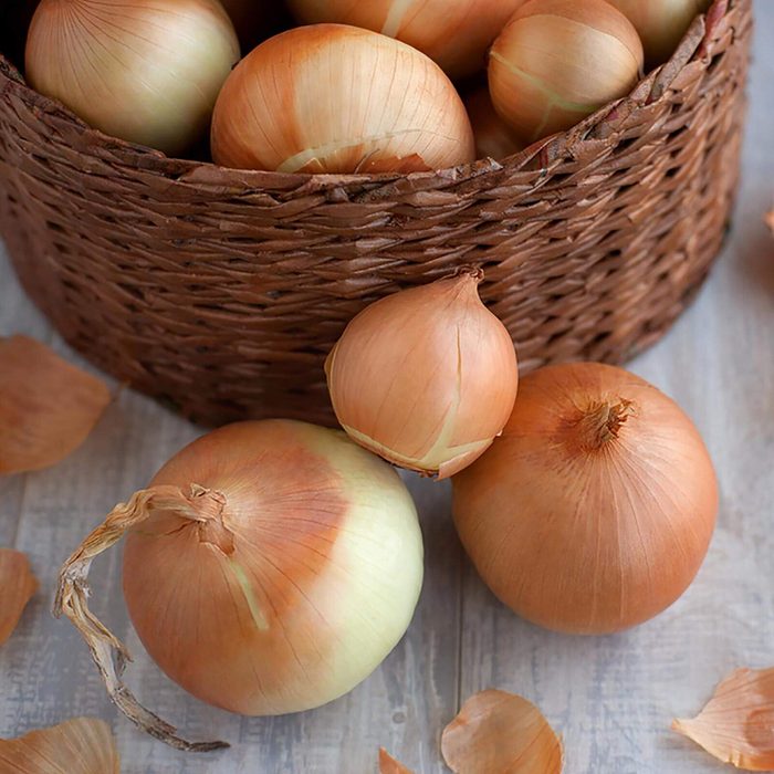 Large onion harvest in a wicker basket.