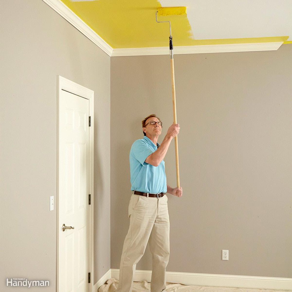 Painting the ceiling yellow with a long roller