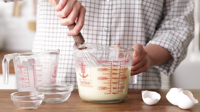 Mixing custard in a measuring cup with a whisk