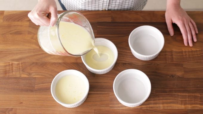 Pouring custard from a measuring cup into custard cups