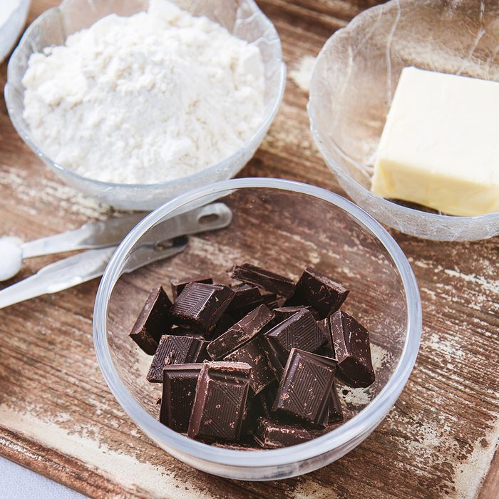 Baking ingredients for chocolate cake muffins or cookies lying ready on wooden kitchen tray.
