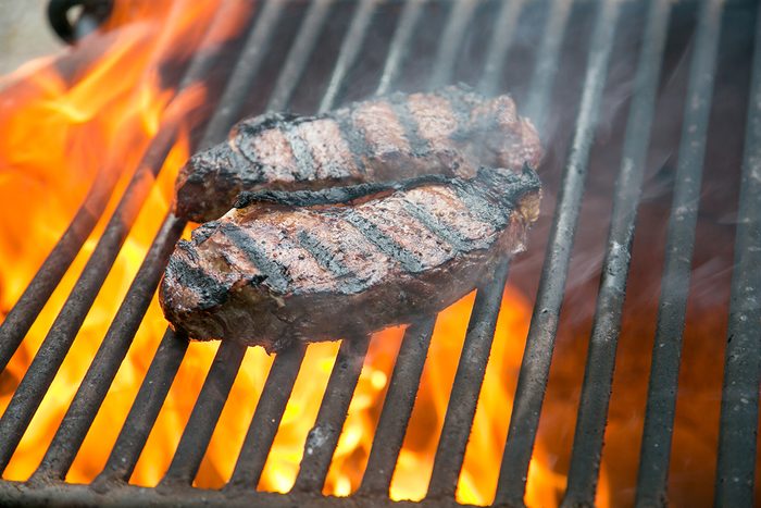 Beef steaks on the grill over wood fire