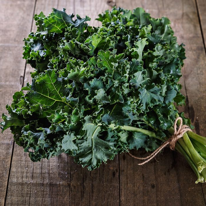 Bunch of organic kale on a rustic wooden background.