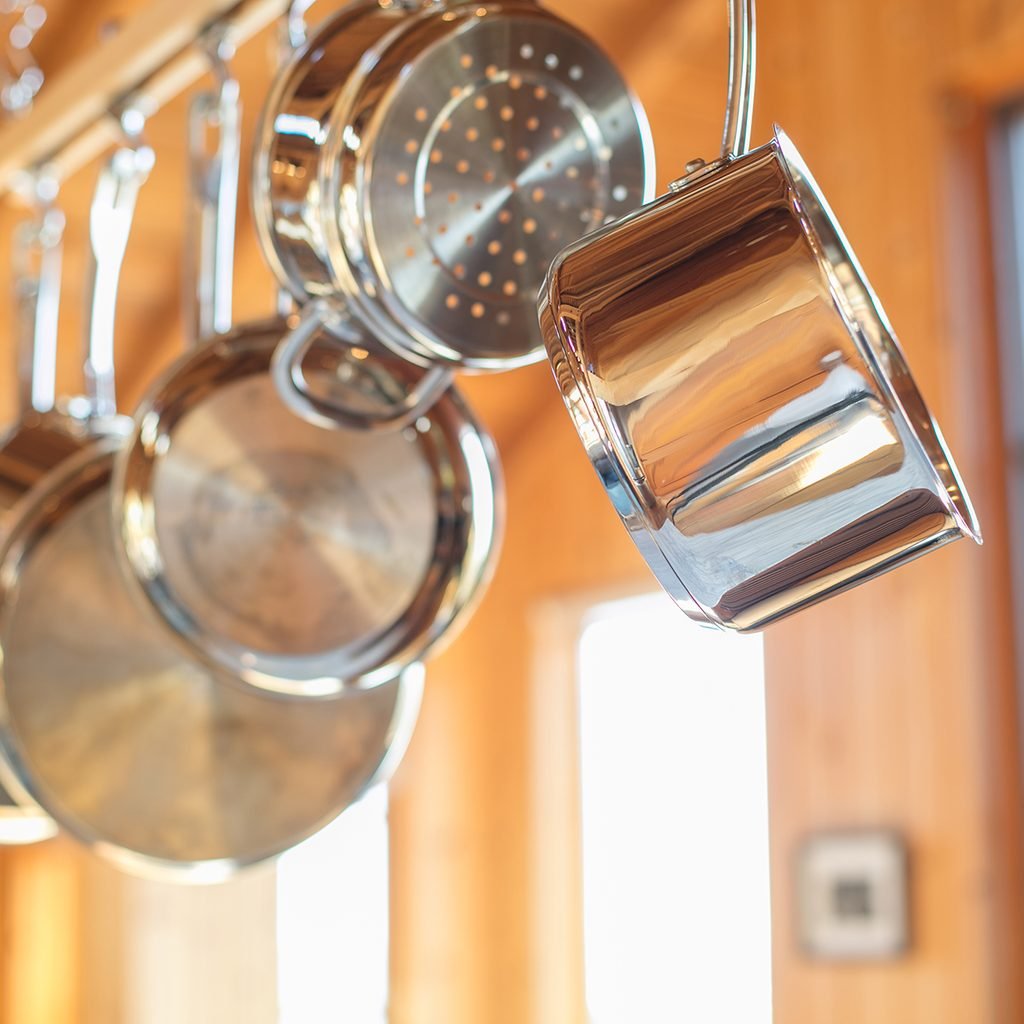 Pots and Pans hanging in Kitchen from wood rack: Stainless steel
