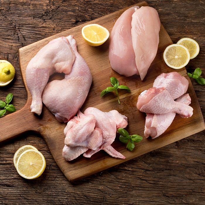 Raw chicken meat on wooden board.