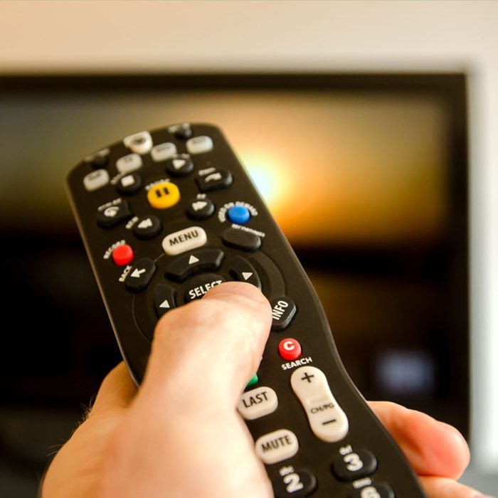 Watching tv and using remote control; Shutterstock ID 137593505