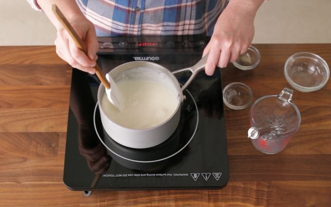 person stirring roux with a rubber spatula