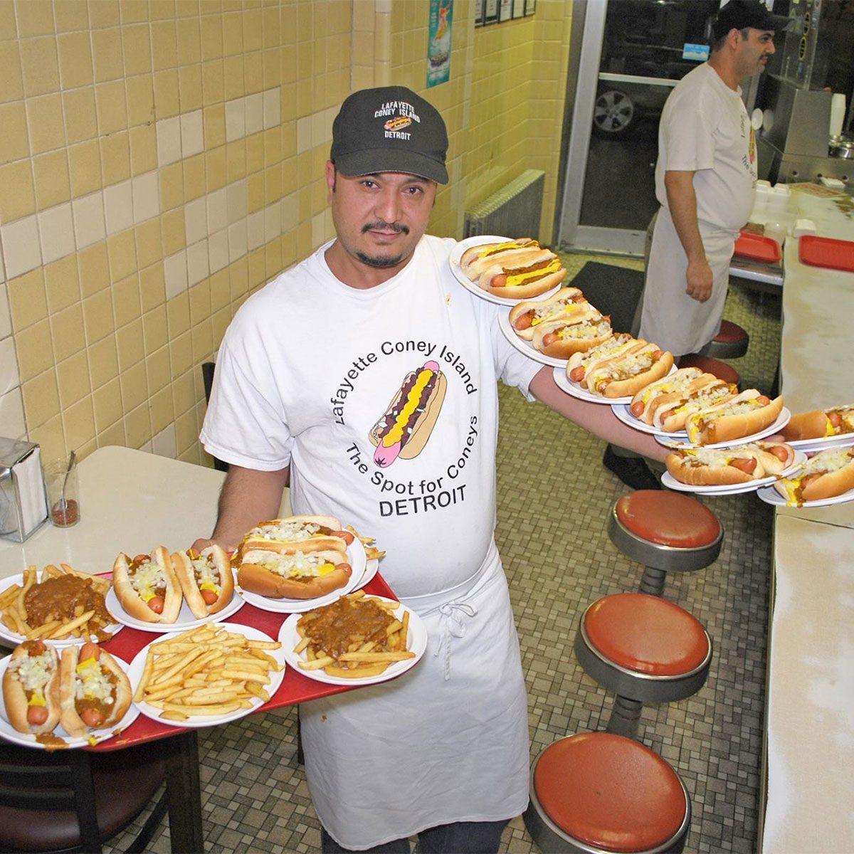 Lafayette Coney Island employee holding a ton of hotdogs