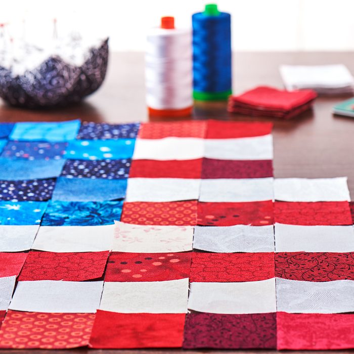 Preparing to sewing of pieces of fabrics that look like a flag of USA
