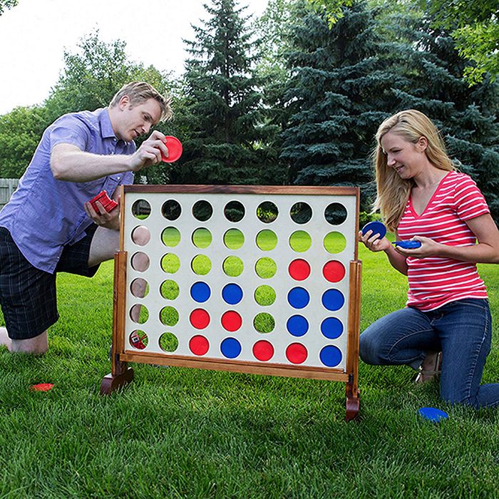 Two people playing connect four in the lawn