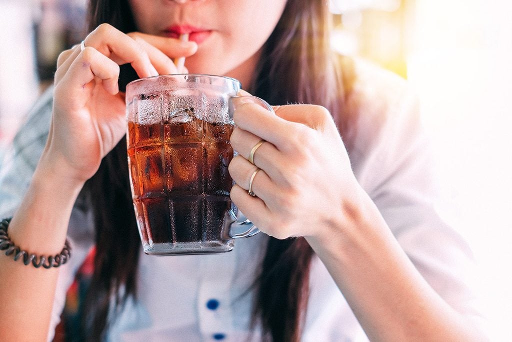 closeup woman drinking ice cola in the glass.food and beverage concept