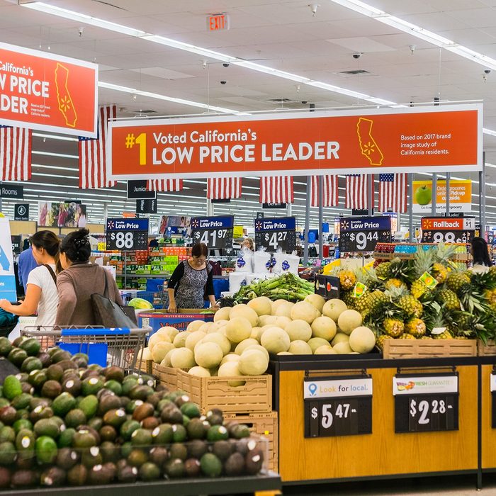 People shopping in the food and vegetable area of one of Walmart's stores in south San Francisco bay area; Banners advertising the low price leader status