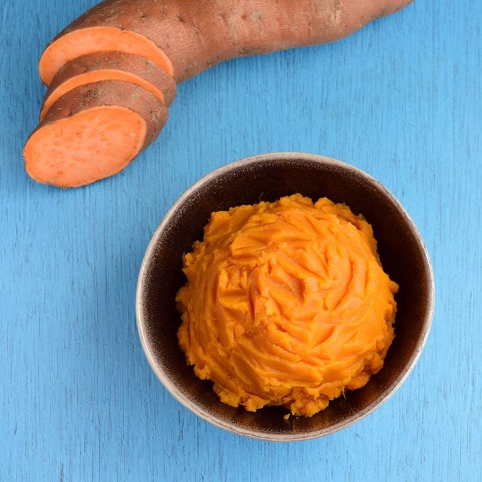 Organic sweet potato puree on blue background