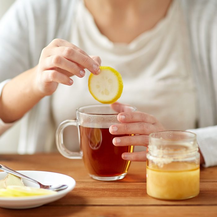 health, traditional medicine and ethnoscience concept - close up of ill woman drinking tea with lemon, honey and ginger at wooden table; Shutterstock ID 531335296; Job (TFH, TOH, RD, BNB, CWM, CM): Taste of Home