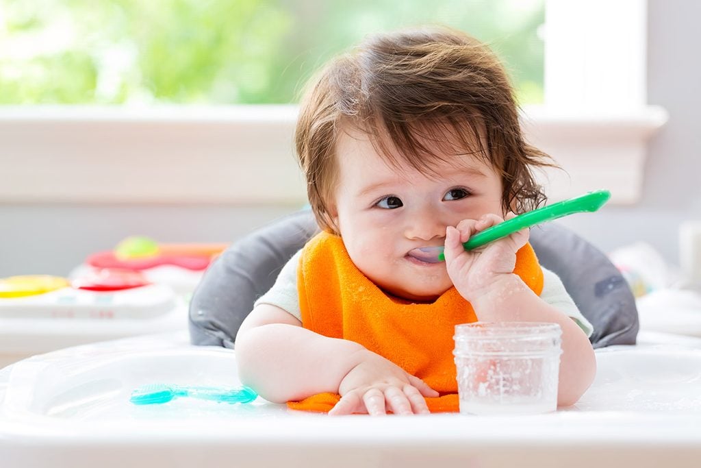 Happy little baby boy eating food with a spoon; Shutterstock ID 673709560; Job (TFH, TOH, RD, BNB, CWM, CM): Taste of Home