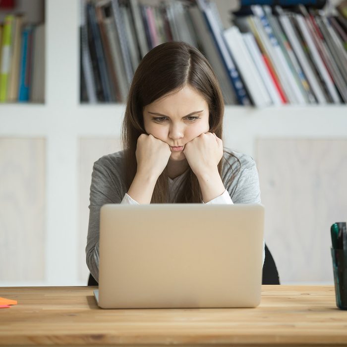 Grumpy not amused office worker looking at laptop screen in office. Young business lady bored with mundane workflow, tired from working too much. Casual businesswoman not happy with boring work task. ; Shutterstock ID 727181035; Job (TFH, TOH, RD, BNB, CWM, CM): Taste of Home