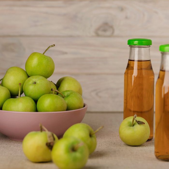 Apple cider vinegar beside apples