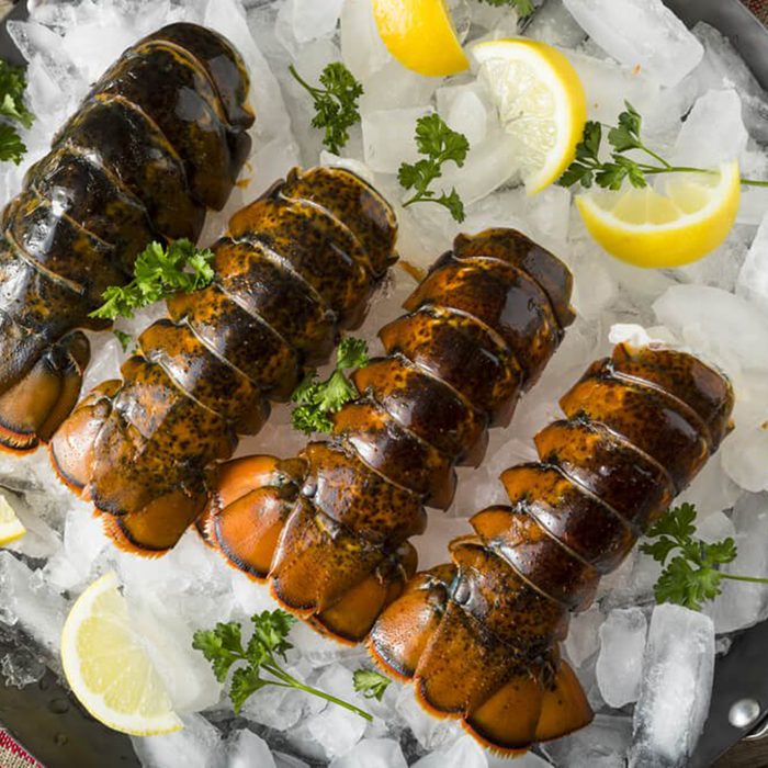 Lobster tails and lemons on ice