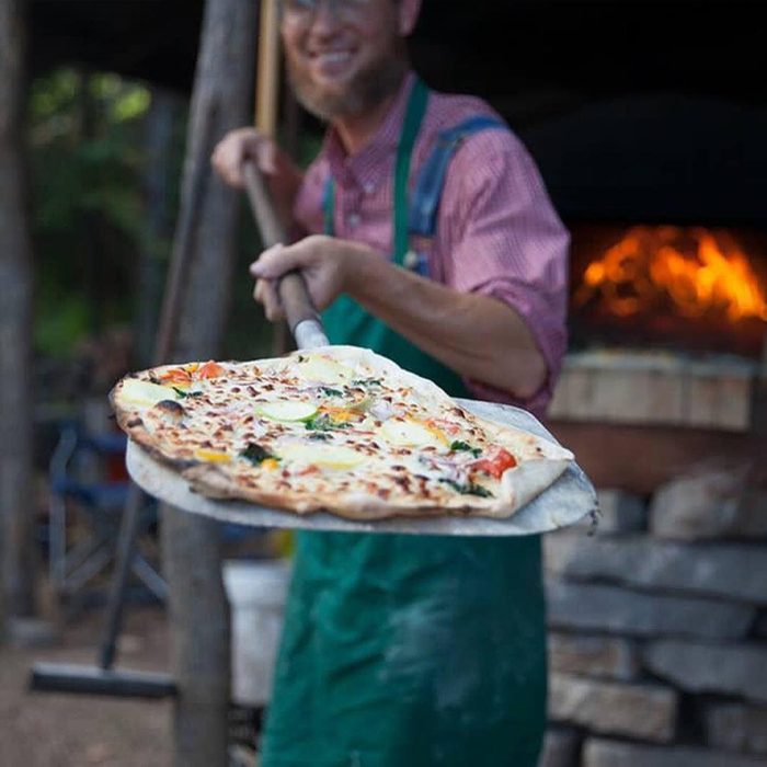 Millsap Farm owner holding pizza paddle