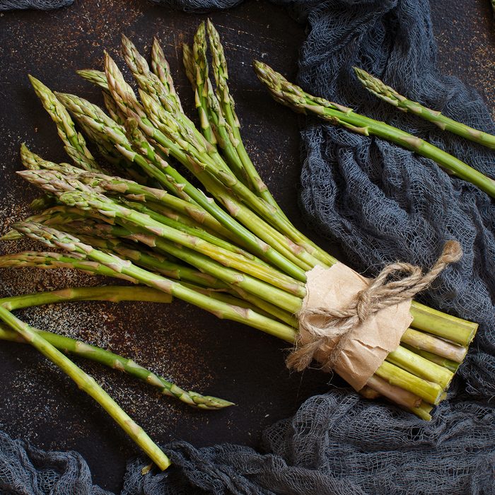 Fresh raw asparagus spears on a dark table